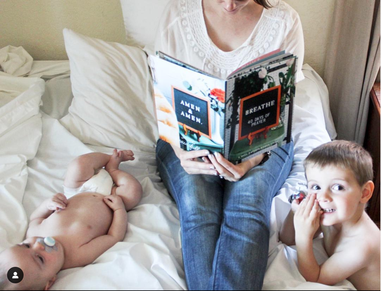 mother reading two small boys beside her. 